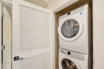 Washer and dryer inside a closet with the closet door opened.